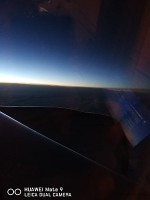 飛行機の中で撮影した日没。夏だからか長い時間、日が沈みませんでした。