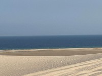 砂漠が海に流れ込む幻想的な景色（コントラスト）、小高い砂丘群が美しい