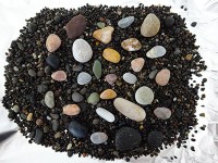 粒の粗い黒い砂に鮮やかな石がちらほら