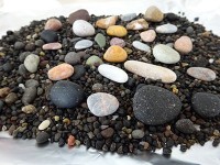 粒の粗い黒い砂に鮮やかな石がちらほら